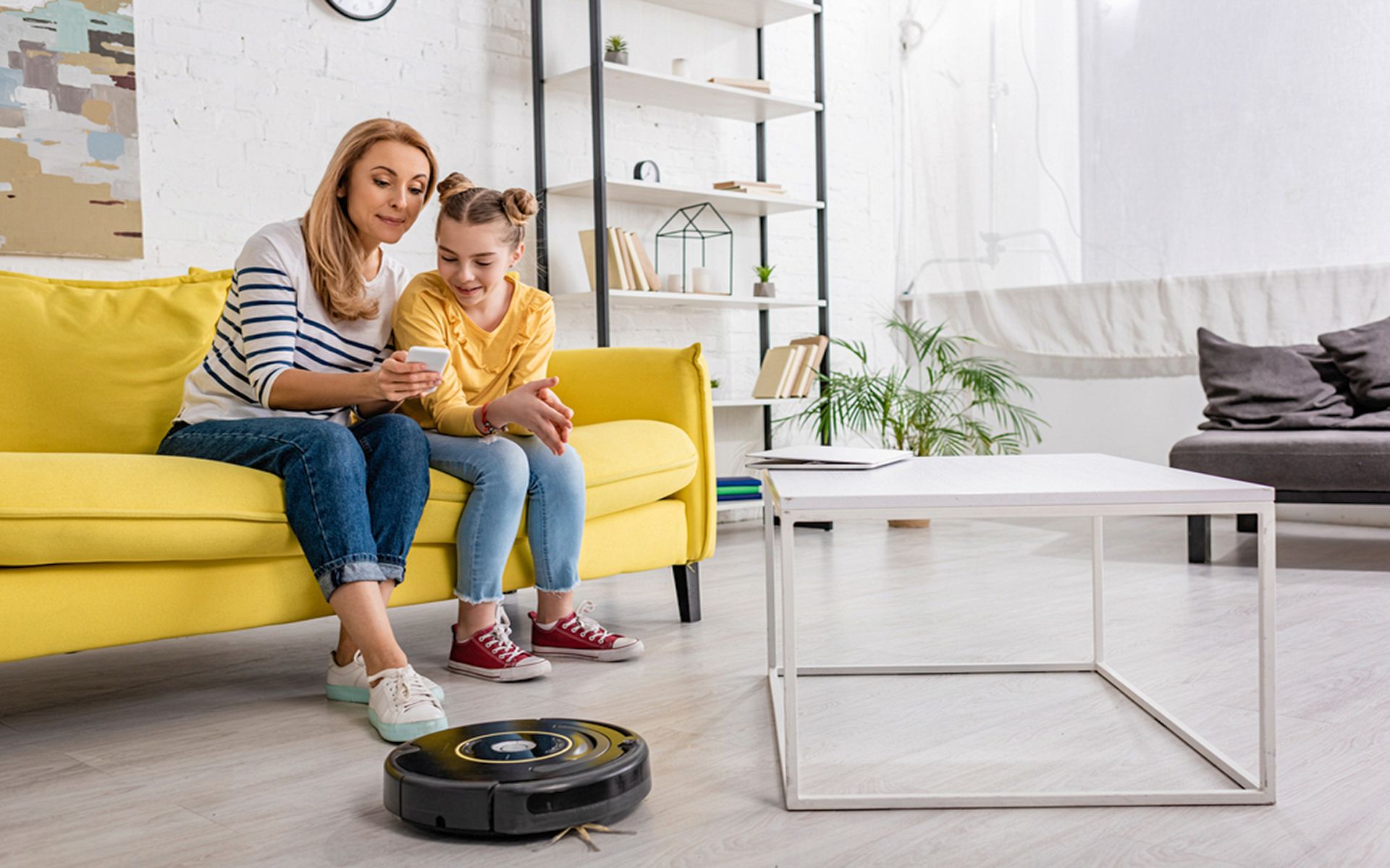 Matka s dcérou a robotický vysávač na vinylovej podlahe.