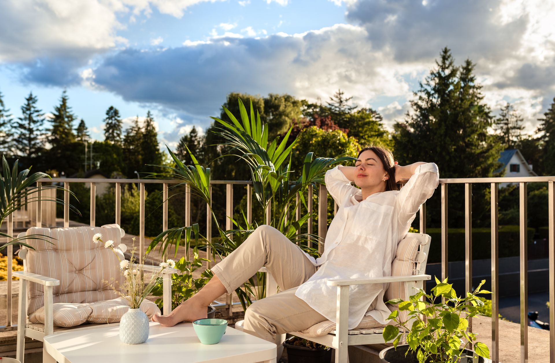 žena odpočíva na svojom krásnom balkóne s umelou trávou