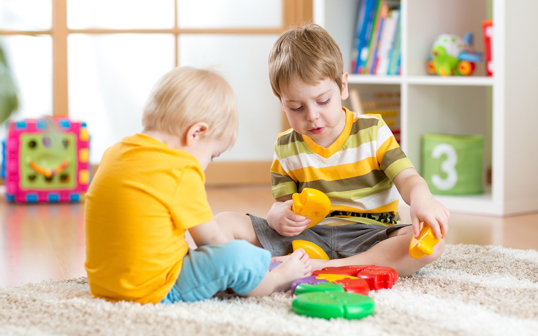 děti si hrají v dětském pokoji na podlaze s kobercem