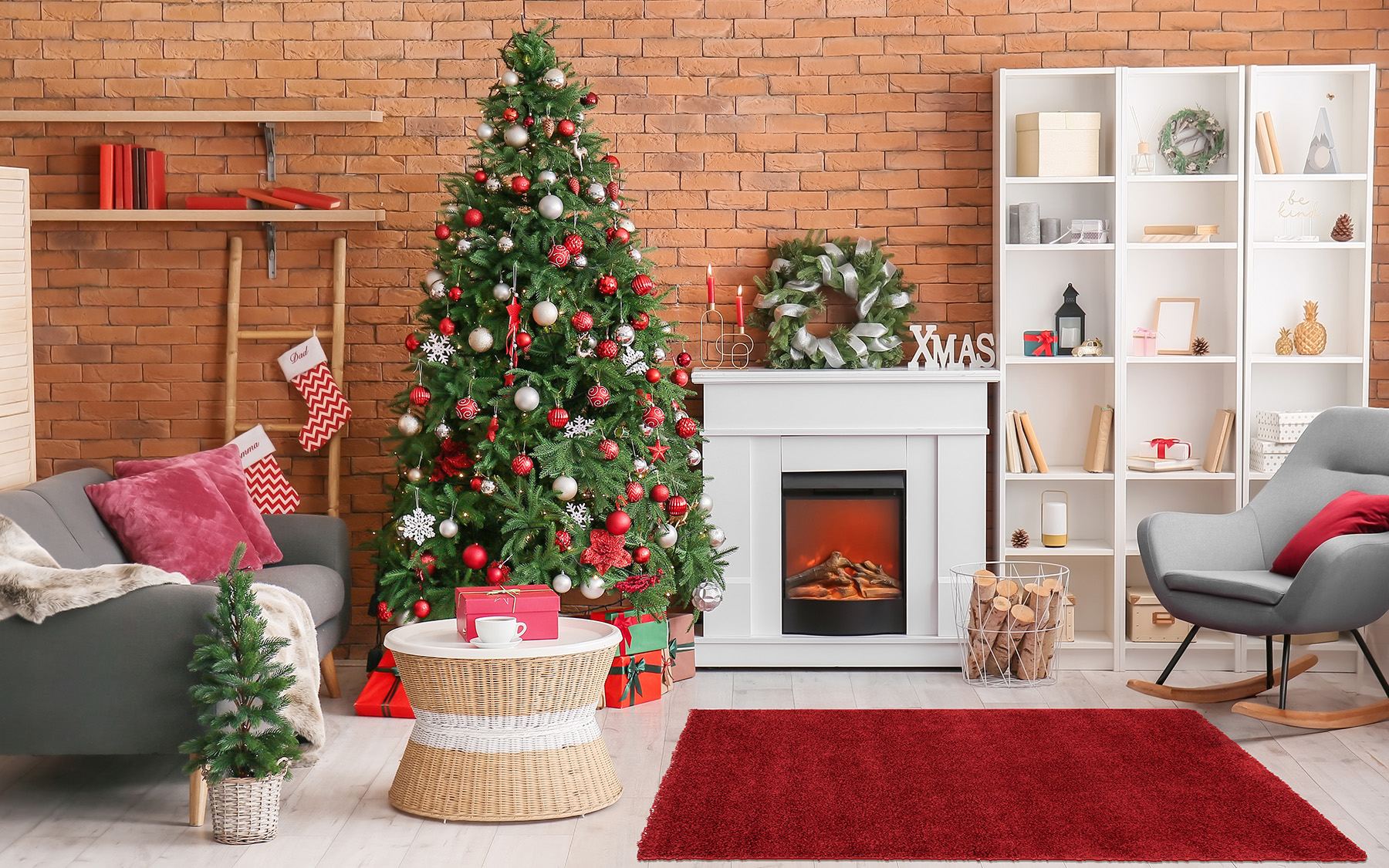 Obývačka s vianočným stromčekom a výzdobou, na zemi červený shaggy koberec.