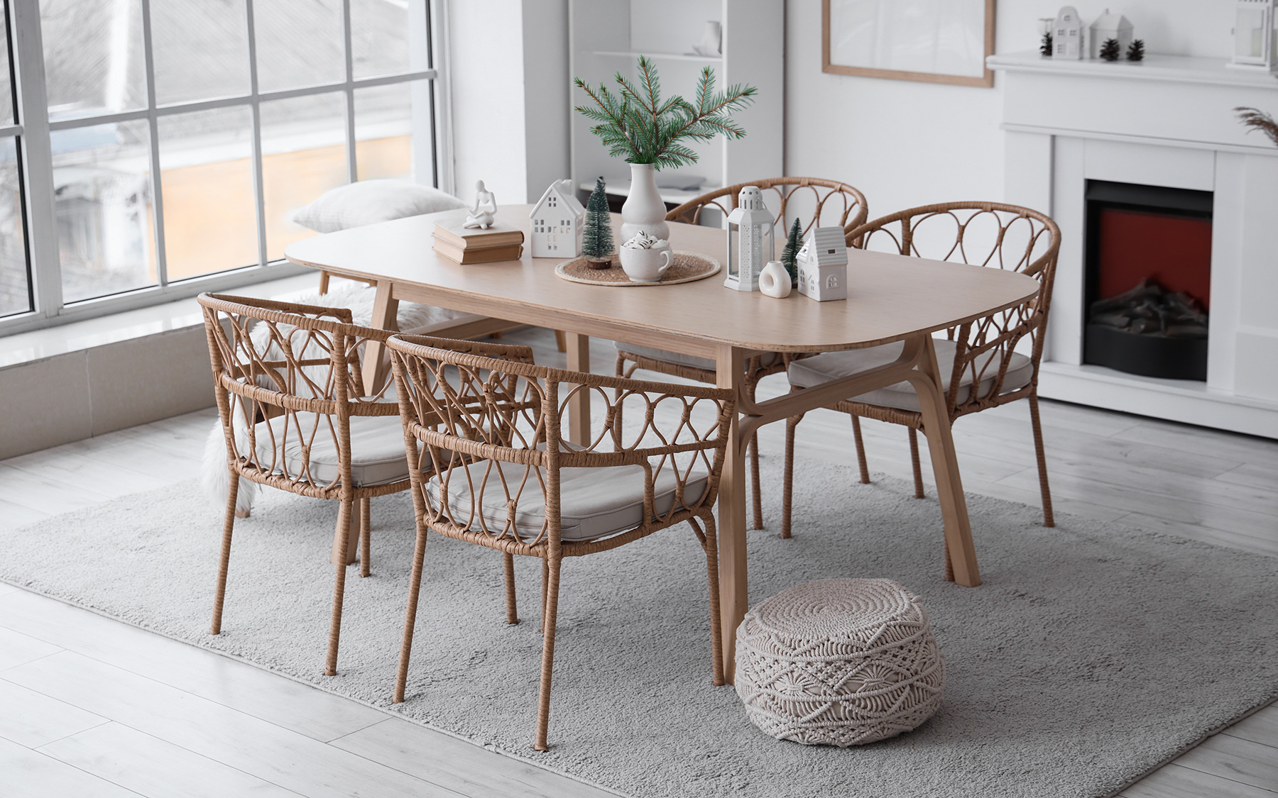 Jedáleň so sivým kusovým kobercom, zimnými dekoráciami a vetvičkami vo váze na stole.