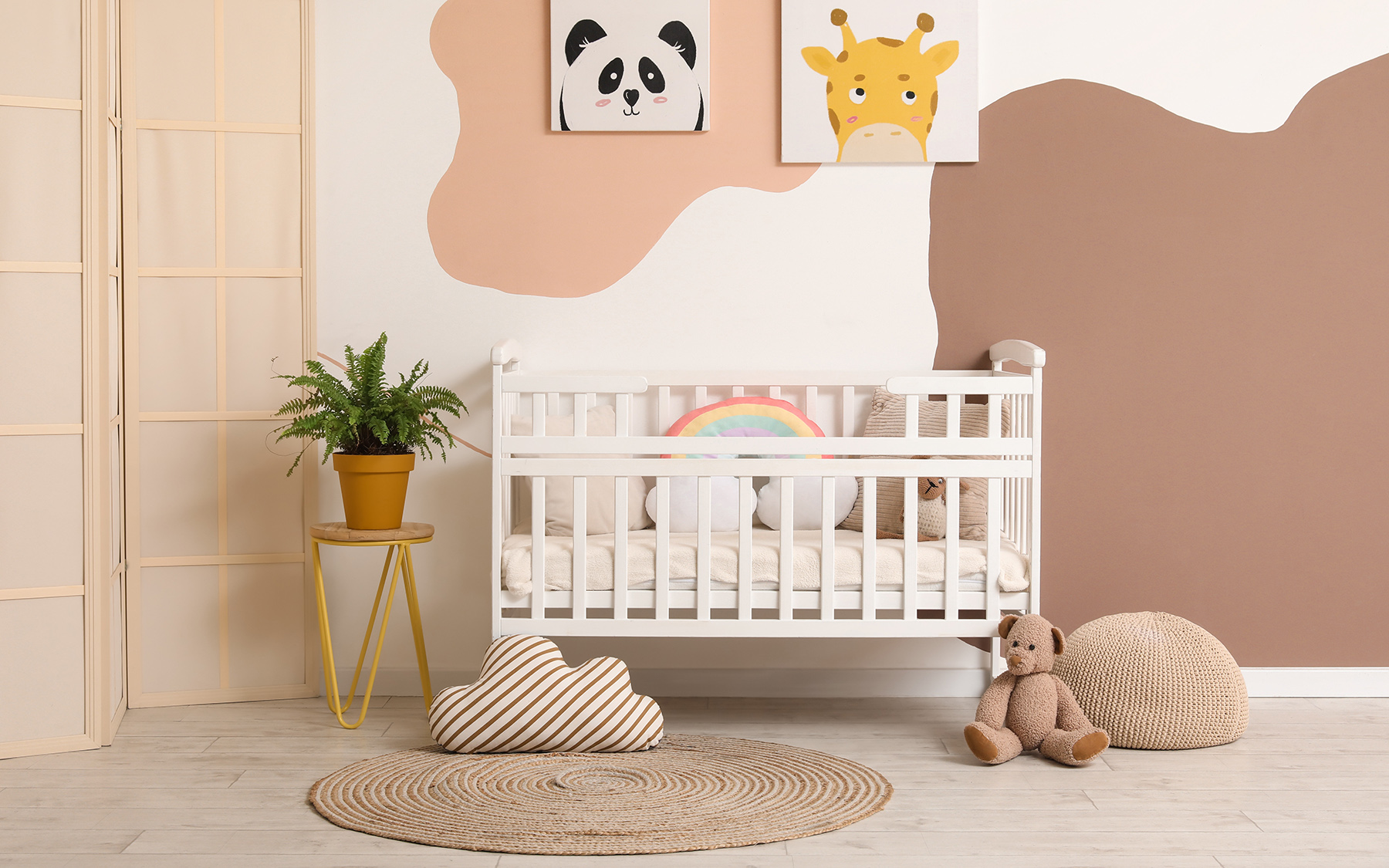 Izba pre bábätko v neutrálnych farbách s detskou postieľkou a okrúhlym kusovým kobercom.