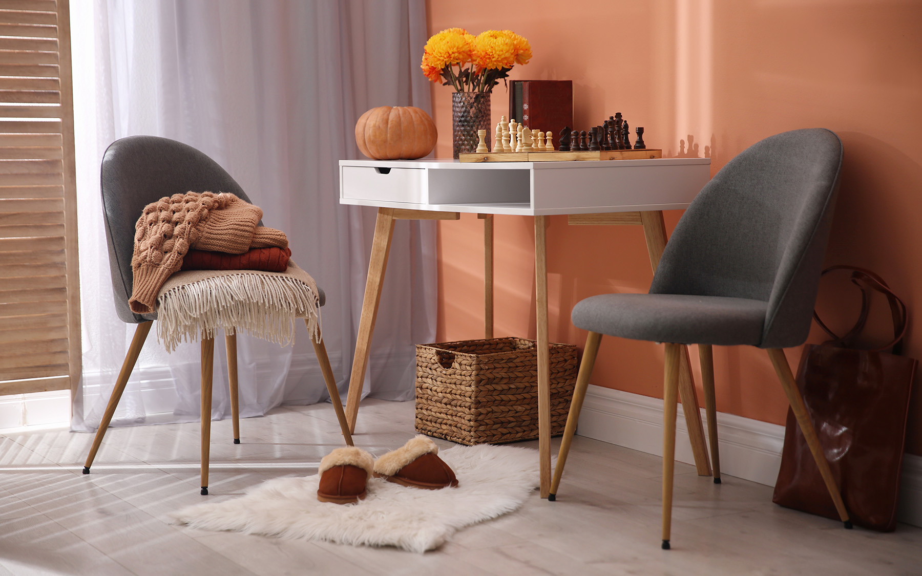 Kout v obývacím pokoji se stolem na šachy, židlemi, kožešinou a doplňky.