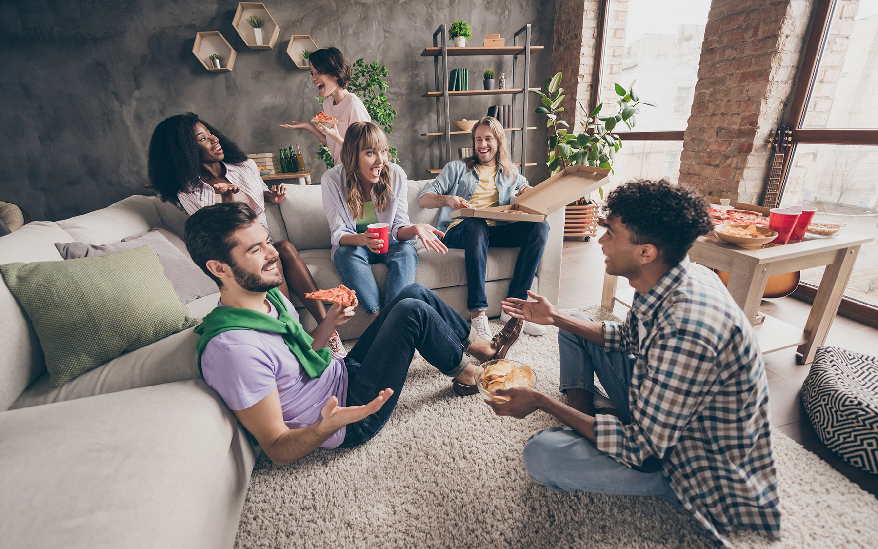 Setkání s přáteli v obýváku se spoustou jídla a posezením na koberci.