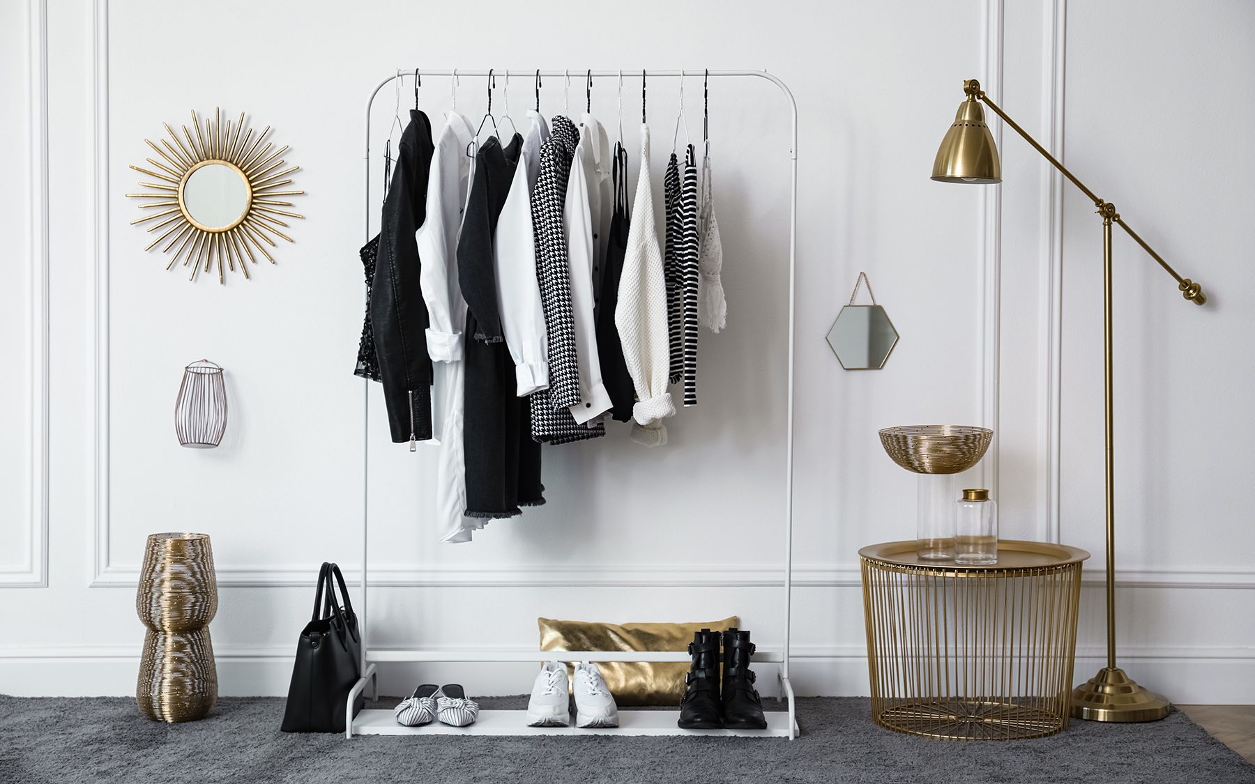 Predsieň s oblečením, sivým kobercom a kovovými doplnkami.