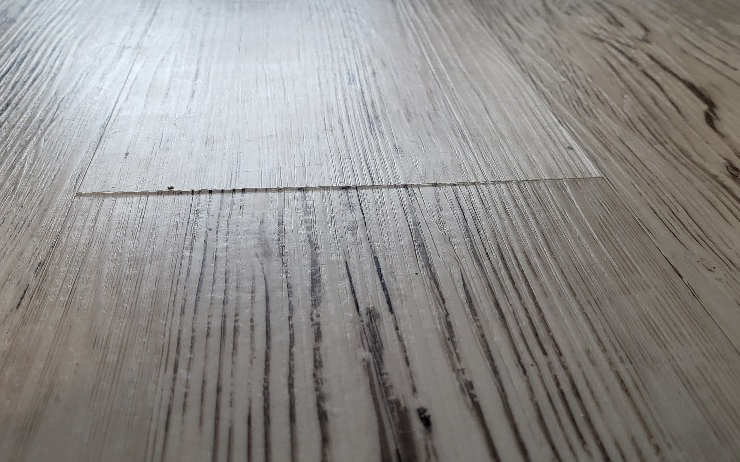 Poškodenie vinylovej podlahy vlhkosťou.