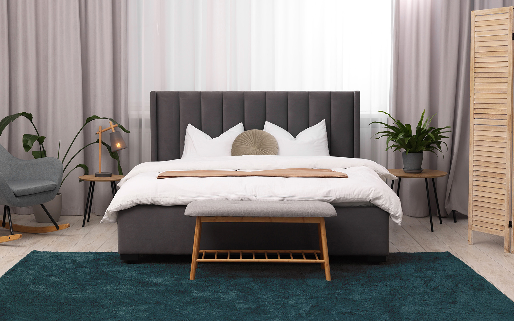Ložnice s tmavě zeleným kobercem u postele.